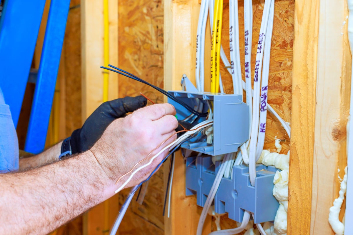 Electrician installing wiring in a newly built home